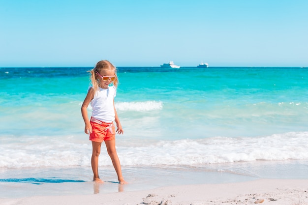 Adorable petite fille à la plage pendant les vacances d'été