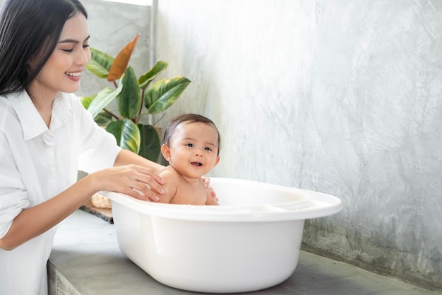 Adorable petite fille prenant un bain avec le concept de l'enfance et de la parentalité de l'enfant de la famille mère