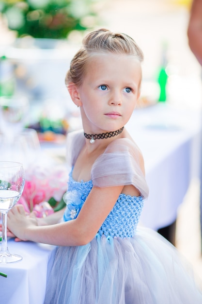 Adorable petite fille en robe incroyable lors d'une cérémonie de mariage en plein air