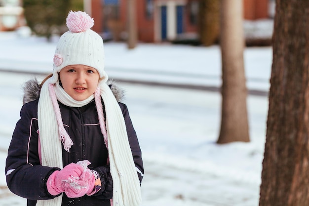 Adorable petite fille s'amusant le jour de l'hiver petite fille jouant dans la rue en hiver