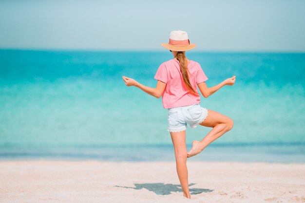 Adorable petite fille s'amuser sur la plage tropicale pendant les vacances