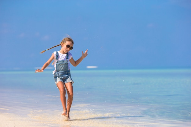 Adorable petite fille souriante heureuse s&#39;amuser sur la plage