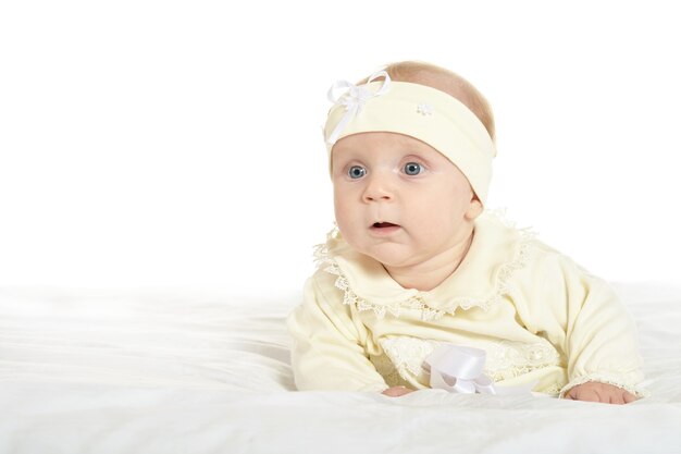 Adorable petite fille en vêtements mignons sur couverture sur fond blanc