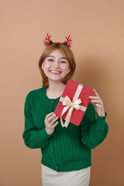 Adorable photo d'une femme attirante avec un beau sourire tenant une boîte-cadeau rouge Concept de Noël et du Nouvel An