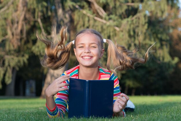 Adorable rat de bibliothèque Écolière lisant des histoires relaxantes pelouse verte Élève mignon aime lire Temps scolaire Développer des apprenants attentionnés qui grandissent et réussissent activement Livre de lecture pour petit enfant