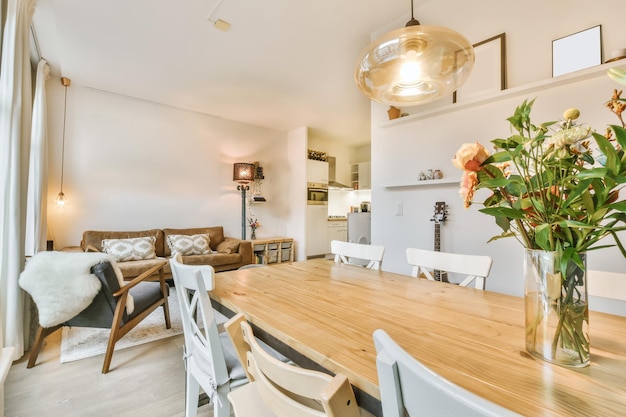 Adorable salle à manger avec une table en bois et un vase avec des fleurs dessus