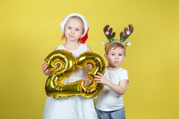 Adorables enfants caucasiens tenant des ballons avec des chiffres et faisant des grimaces