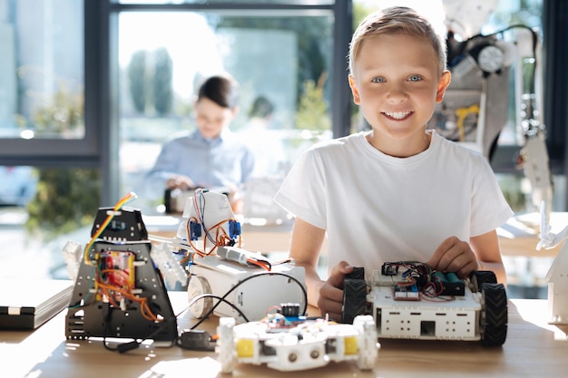 Adorables enfants pré-adolescents inspectant un atelier de véhicules robotiques