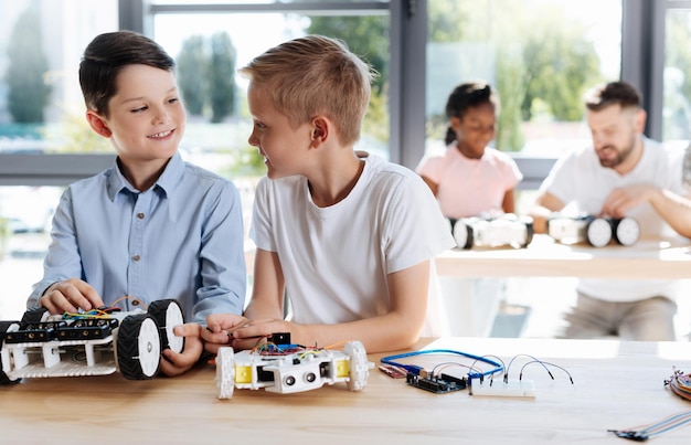 Adorables enfants pré-adolescents inspectant un atelier de véhicules robotiques