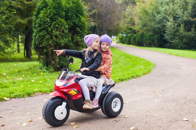 Photo adorables petites filles à bicyclette dans le parc verdoyant