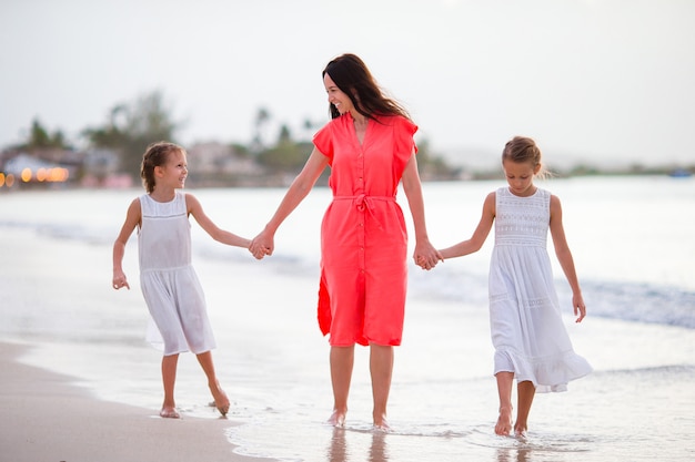 Adorables petites filles et jeune maman sur la plage blanche