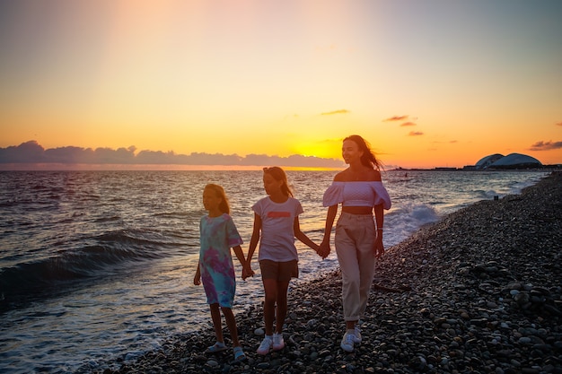 Adorables petites filles et jeune mère sur la plage blanche tropicale