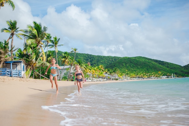 Photo adorables petites filles marchant sur la plage