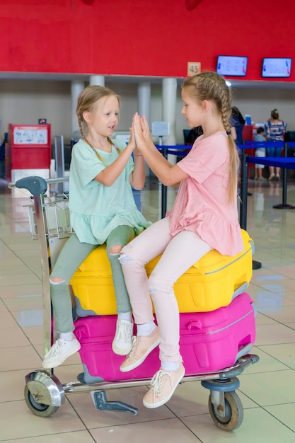 Adorables petites filles s'amusant à l'aéroport en attendant l'embarquement