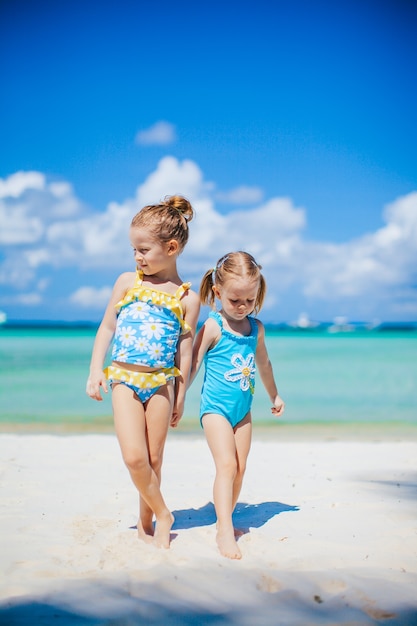 Adorables petites filles s'amusant sur la plage