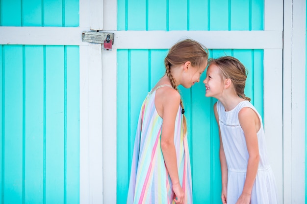 Adorables petites filles en vacances d'été, maison traditionnelle des Caraïbes colorée