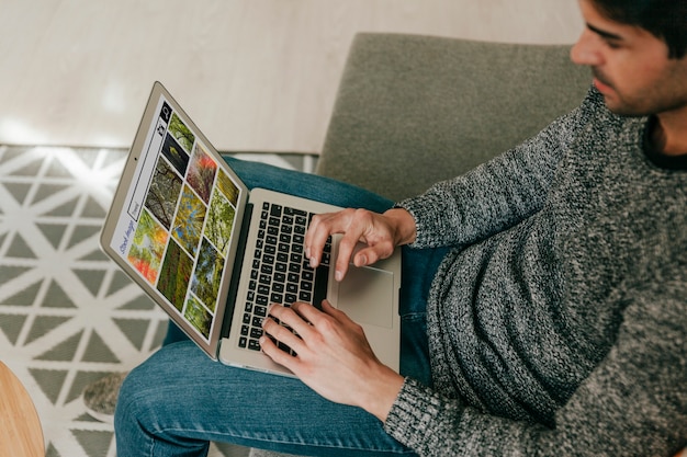 Adulte à angle élevé à la recherche d'images de stock sur un ordinateur portable