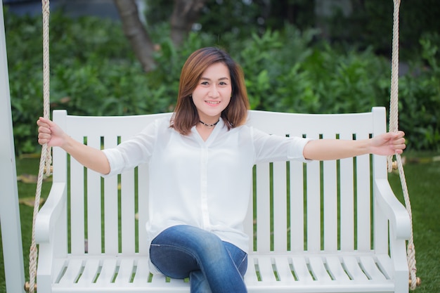 Adulte célibataire de femmes asiatiques se détendre assis sur un banc dans le parc. Profitez du concept de vie en bonne santé.