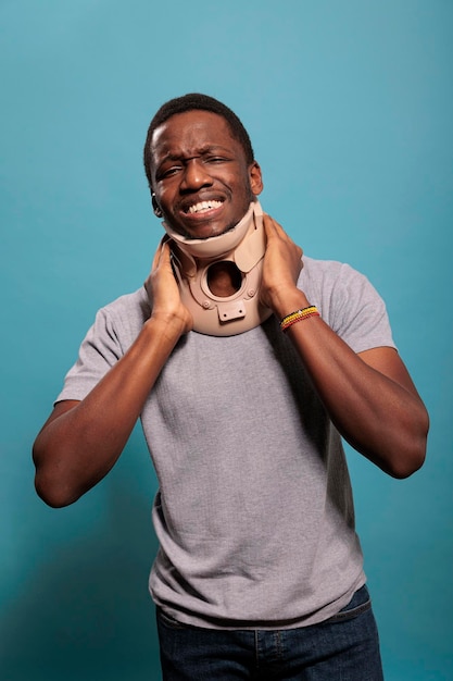 Adulte déçu portant un collier cervical pour soigner une blessure physique après un accident osseux foulé. Jeune homme avec de la mousse de cou souffrant de vertèbres fracturées, souffrant de rééducation.