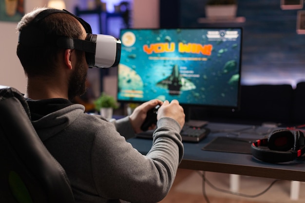 Adulte Utilisant Des Lunettes Vr Pour Gagner Des Jeux Vidéo Sur Ordinateur.  Homme Avec Manette Et Lunettes De Réalité Virtuelle Jouant Au Jeu Pour  S'amuser Avec L'activité Moderne. Gamer Gagnant La Compétition