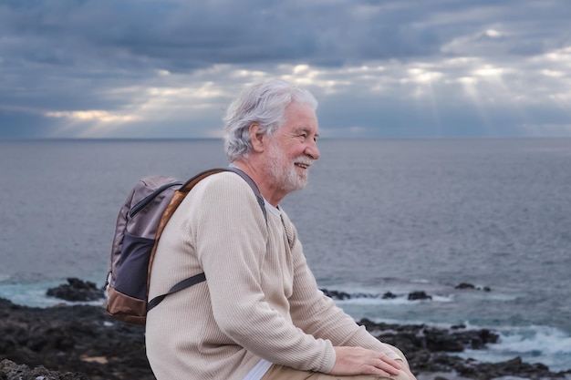 Adulte vieil homme barbu senior se reposant pendant une excursion en mer regardant l'horizon au-dessus de l'eau