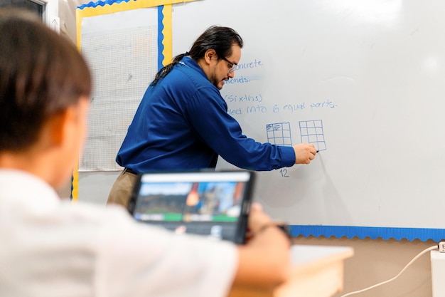 Photo adultes professeur hispanique homme enseignant devant un tableau blanc