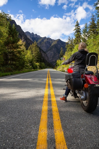 Adventurous Caucasian Woman sur une moto profitant du paysage canadien
