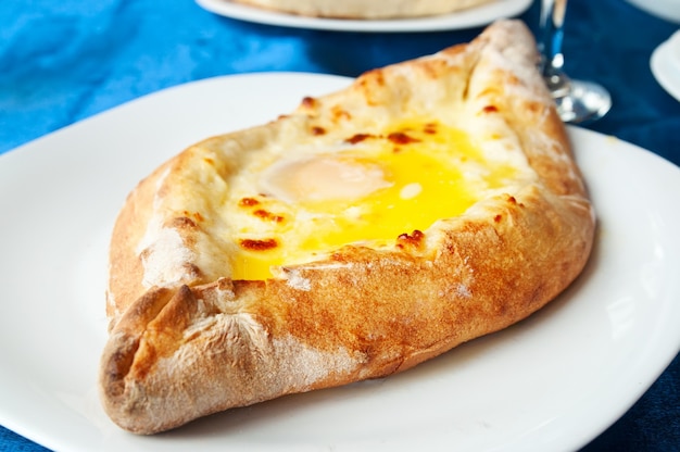 Adzhar khachapuri - pâtisserie géorgienne traditionnelle sur plat au restaurant