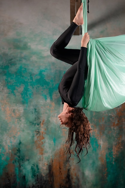 Aero yoga une jeune femme faisant du yoga ou s'étendant sur une suspension