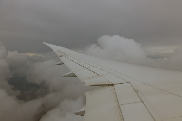 Aéronef de l'aile en altitude pendant l'avion volant au-dessus des nuages