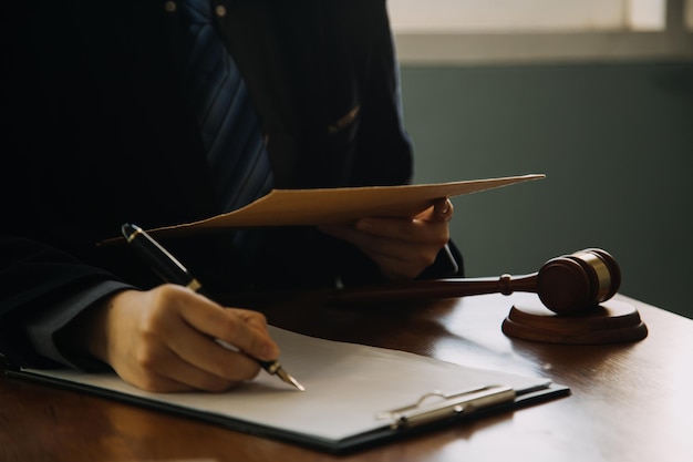 Affaires et avocats discutant des documents contractuels avec une échelle en laiton sur le bureau au bureau