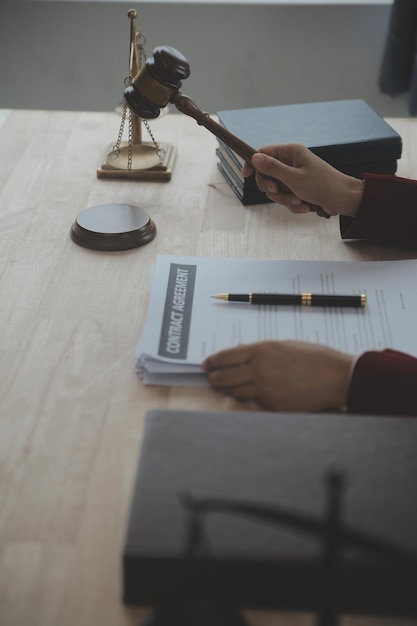 Affaires et avocats discutant des documents contractuels avec une échelle en laiton sur le bureau au bureau