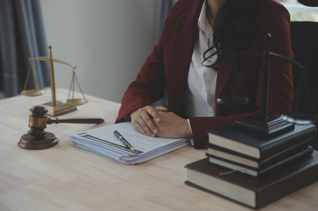 Affaires et avocats discutant des documents contractuels avec une échelle en laiton sur le bureau au bureau