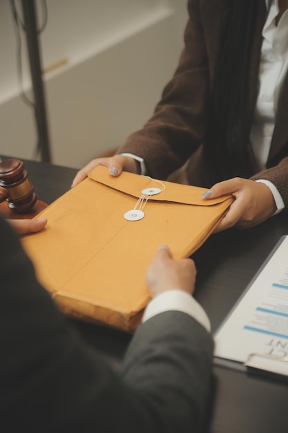 Affaires et avocats discutant des documents contractuels avec une échelle en laiton sur le bureau au bureau