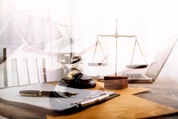 Affaires et avocats discutant des documents contractuels avec une échelle en laiton sur le bureau au bureau