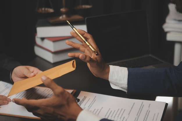 Affaires et avocats discutant des documents contractuels avec une échelle en laiton sur le bureau au bureau