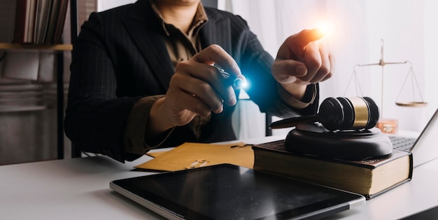 Affaires et avocats discutant des documents contractuels avec une échelle en laiton sur le bureau au bureau