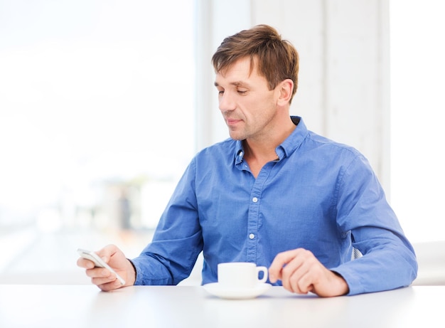 affaires, communication, concept de technologie moderne - homme d'affaires avec smartphone et tasse de café