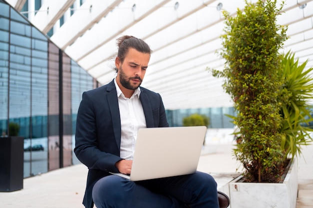 Affaires en déplacement Homme d'affaires travaillant sur son ordinateur portable dans la rue