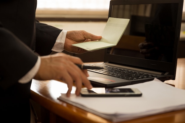 Affaires financières main tenir la déclaration du livre et travailler avec un ordinateur portable.