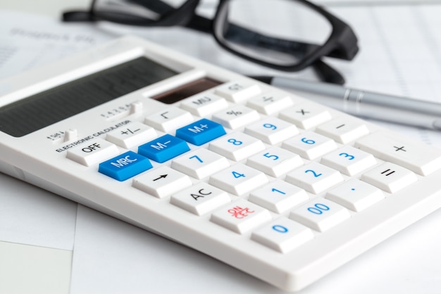 Affaires nature morte avec calculatrice sur table au bureau.