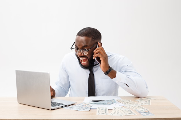 Affaires et succès. Bel homme afro-américain réussi portant costume formel, à l&#39;aide d&#39;un ordinateur portable pour le travail à distance