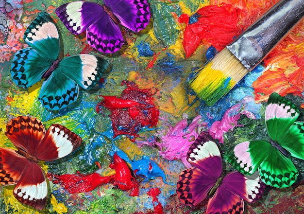 un affichage coloré de papillons et de plumes avec une plume rouge sur le fond.