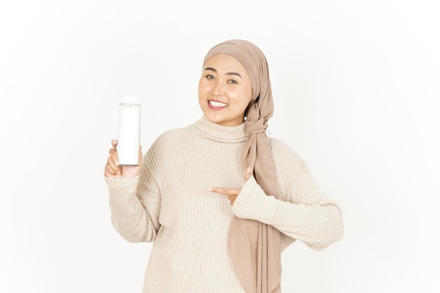 Affichage et présentation d'une bouteille vierge de belle femme asiatique portant le hijab isolé sur fond blanc