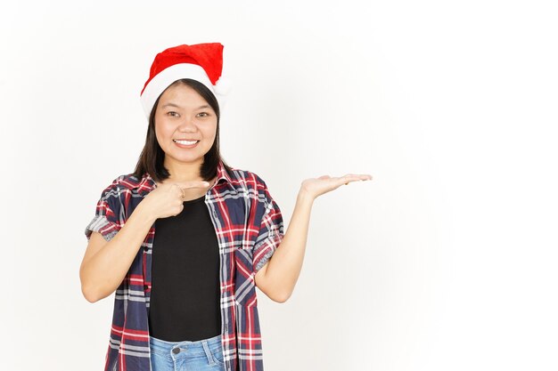 Affichage et présentation du produit sur la paume d'une femme asiatique portant une chemise à carreaux rouge et un bonnet de noel