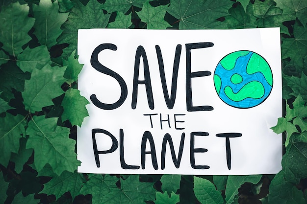 Affiche avec l'inscription sauver la planète dans la forêt parmi les plantes