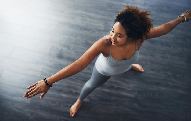 Afin de rester en forme, vous devez vous étirer Prise de vue en grand angle d'une jeune femme pratiquant le yoga