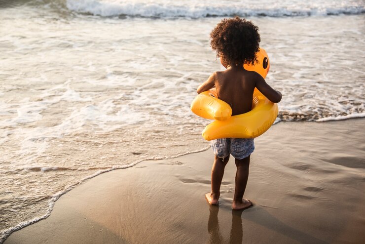 Photo africain petit garçon jouant à la plage