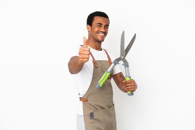 African American gardener man holding sécateur sur fond blanc isolé avec les pouces vers le haut parce que quelque chose de bien s'est passé