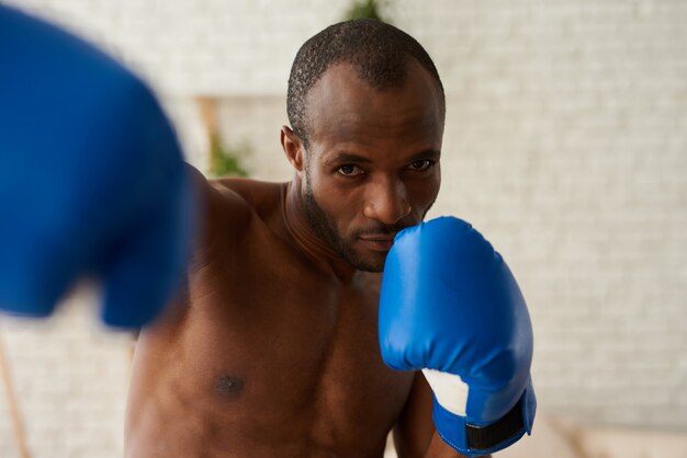 Photo afro-américain de boxe en gants à la maison.